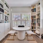 White table and stools in flex space of Greenport, NY home remodel with built-in shelving