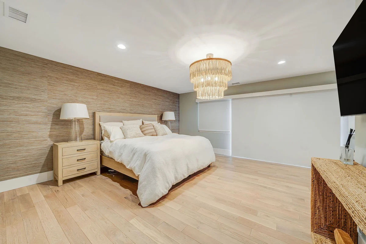 Remodeled bedroom with chandelier in Islip, NY condo by Kuhn Construction-1