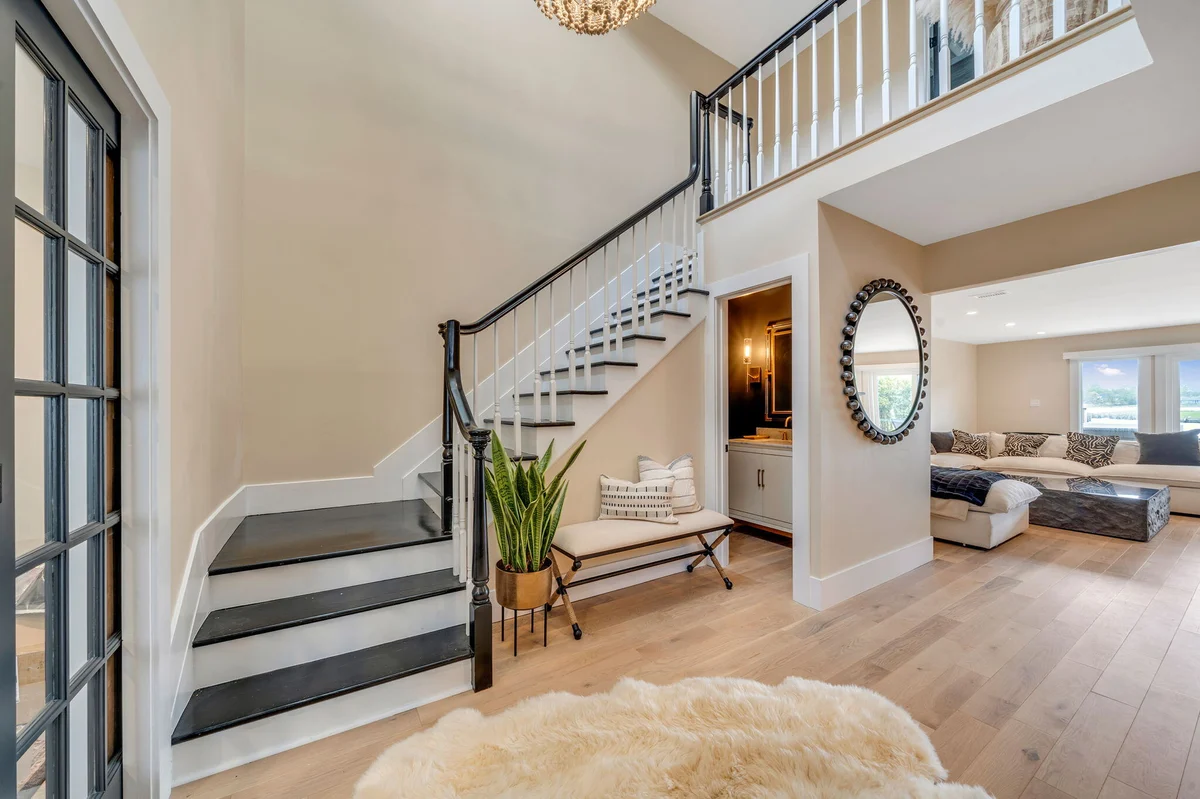 Entryway with stairs and view into living room by Kuhn Construction