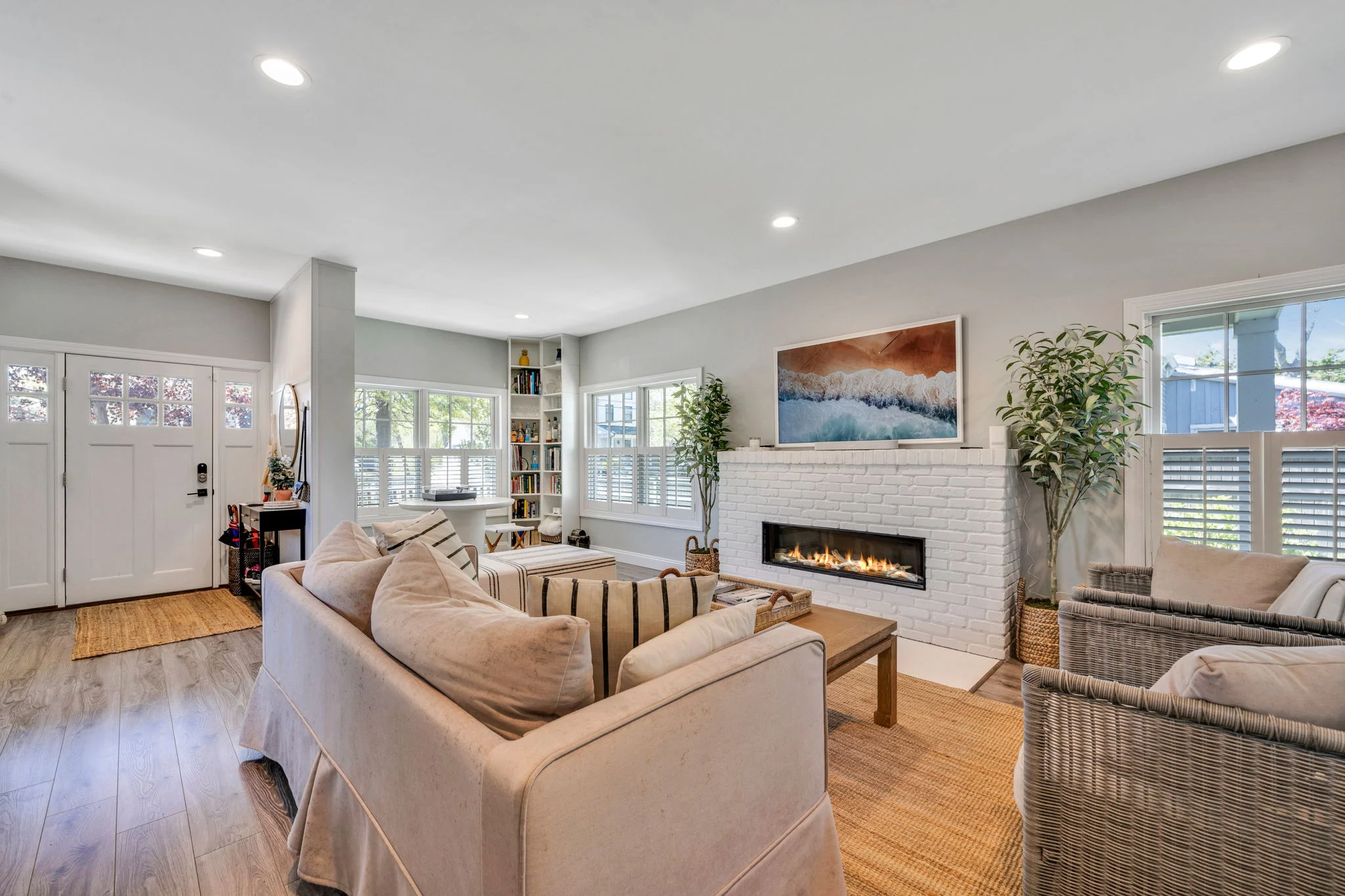 Living room remodel with painted brick fireplace and recessed lighting by Kuhn Construction