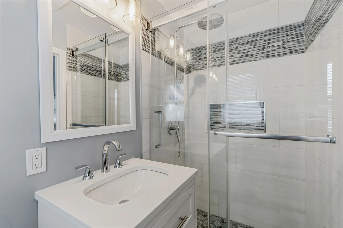 Massapequa, NY bathroom remodel by Kuhn Construction showcasing walk-in en suite shower and vanity