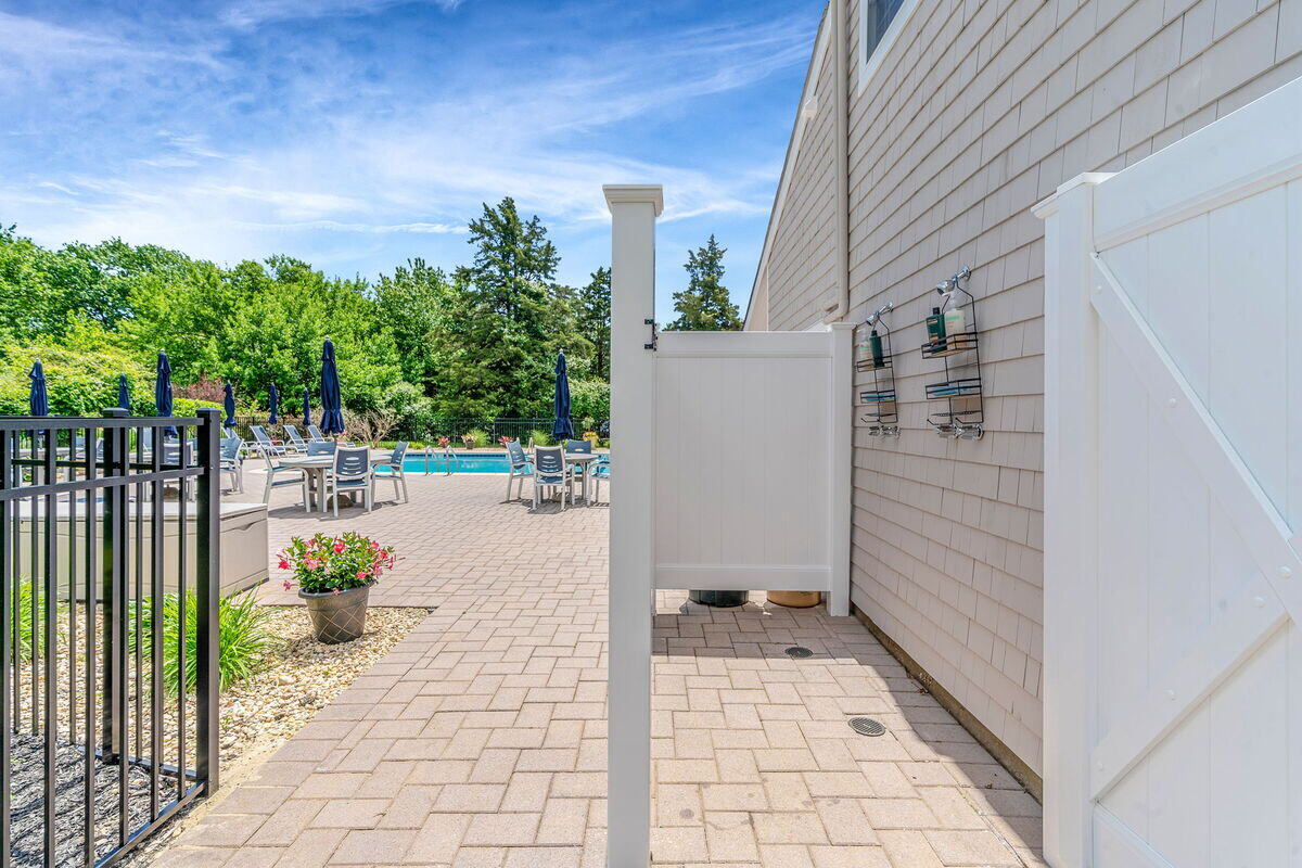 PVC fencing around outdoor shower in condo complex poolhouse remodel in Islip, NY by Kuhn Construction