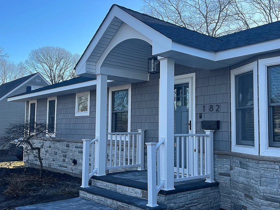 Portico addition f Patchogue, NY home exterior with white columns and vinyl railings by Kuhn Construction